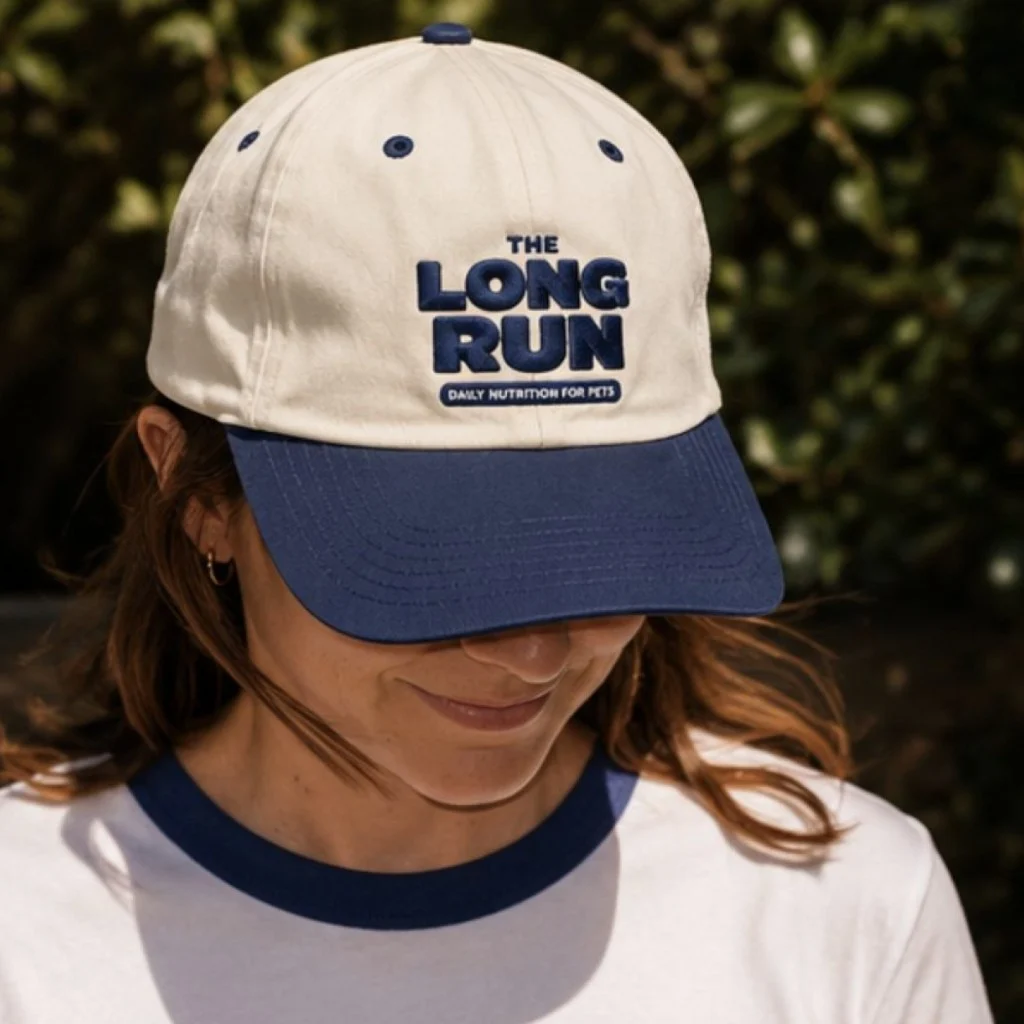 Woman outdoors in a cream and navy The Long Run cap and a navy ringer tee